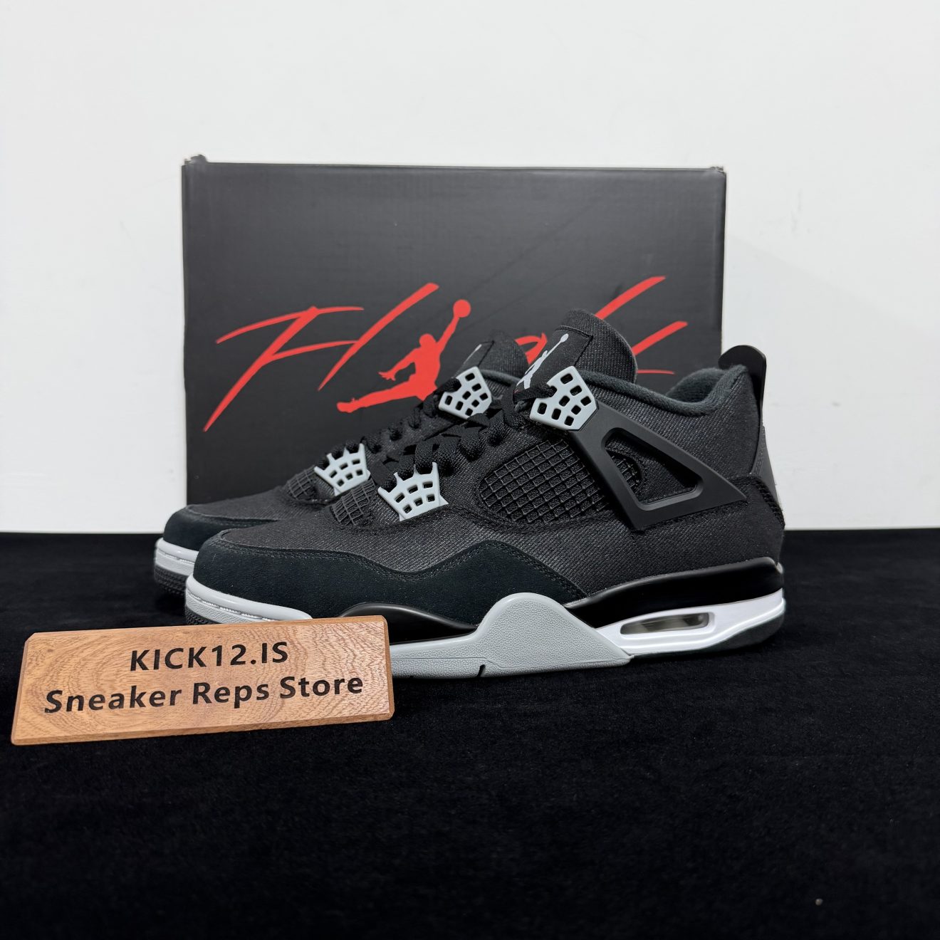 Jordan 4 Black Canvas Reps with box displayed on table